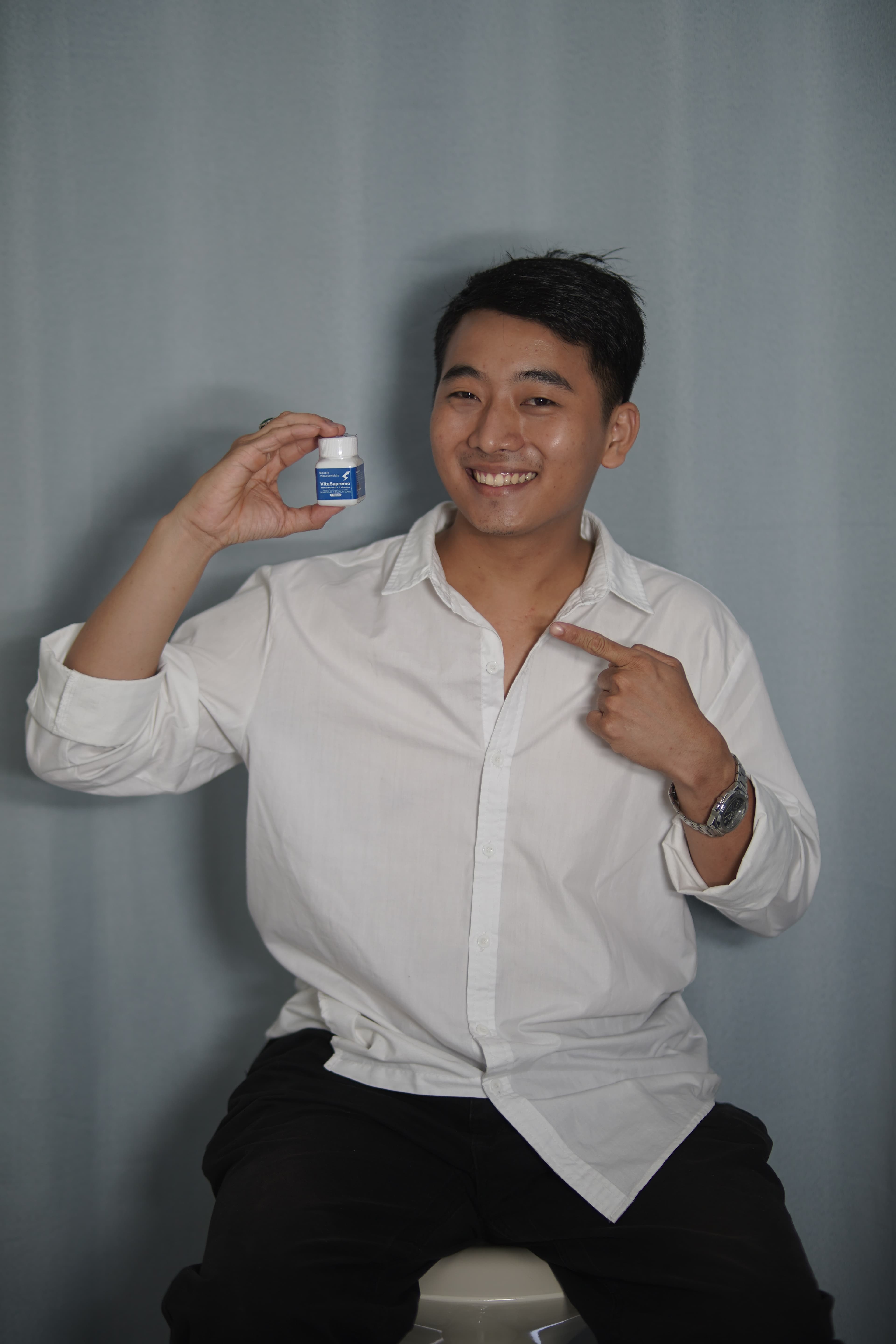 Active professional holding VitaSupremo bottle with confidence